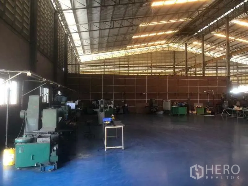 Warehouse for sale in Rayong - Open manufacturing zone with blue epoxy floor and steel truss roof.