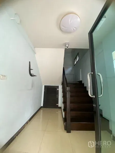 Home Office for rent in Don Mueang, Bangkok - Entrance foyer with glass door and dark wood staircase.
