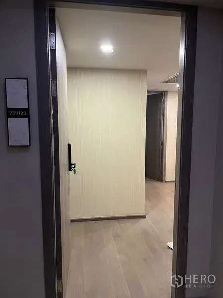公寓 出租在Pathum Wan, Bangkok - 公寓入口走廊，浅木地板与电子门锁。