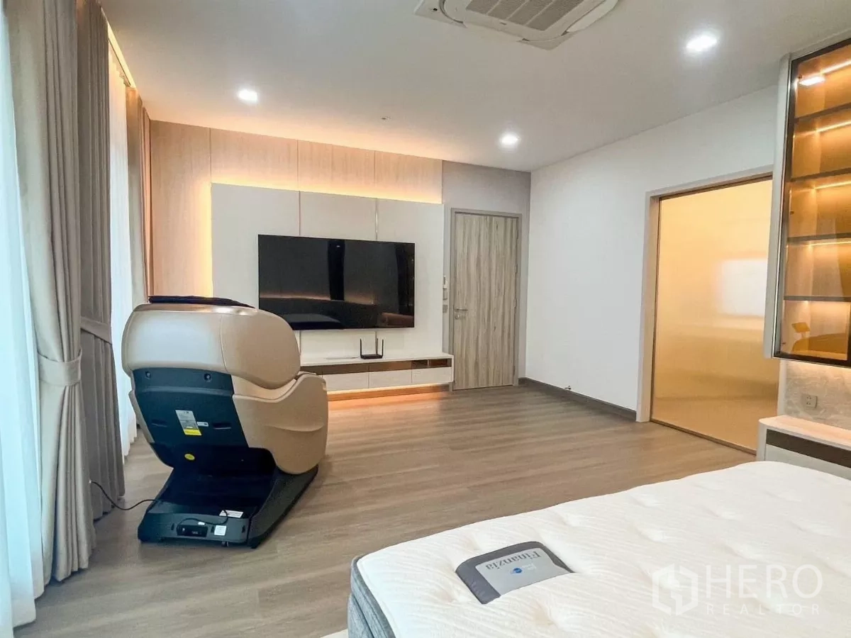 บ้าน ให้เช่าหรือขายในPrawet, Bangkok - ห้องนอนใหญ่กว้าง พื้นไม้ ผนังทีวี หน้าต่างบานใหญ่ และเก้าอี้นวด