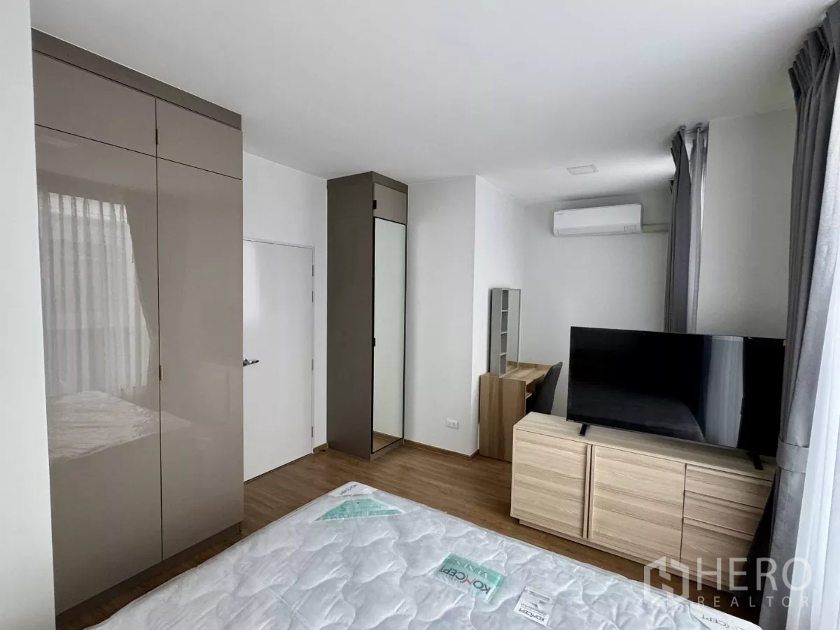 Townhouse for rent in Bang Phli, Samut Prakan - Bright master bedroom with wardrobes, TV console, desk and air conditioning