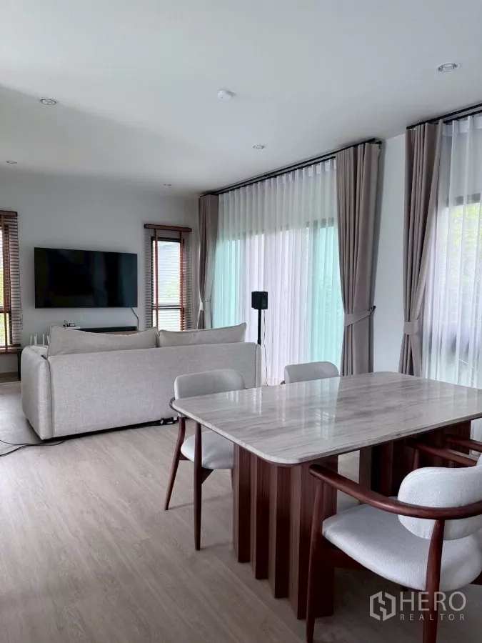 บ้าน ให้เช่าในLat Krabang, Bangkok - พื้นที่นั่งเล่น‑รับประทานอาหารแบบโอเพ่น พร้อมโต๊ะหินอ่อนและหน้าต่างสูงจรดเพดาน