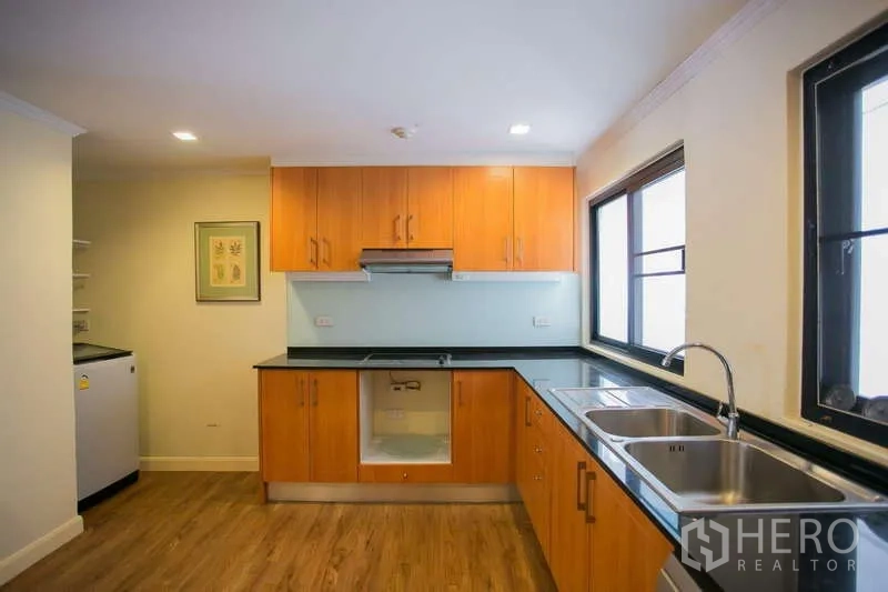 คอนโด ให้เช่าหรือขายในWatthana, Bangkok - มุมครัว อ่างล้างสองหลุม เคาน์เตอร์สีดำ และผนังกระจก