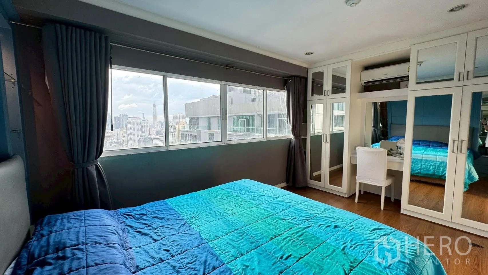 Condominium for rent or sale in Watthana, Bangkok - Master bedroom featuring mirrored wardrobes, dressing desk and panoramic windows.