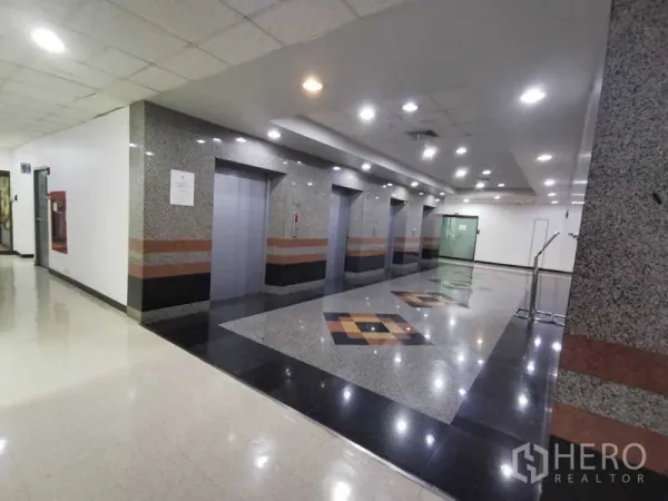 办公空间 出租在Watthana, Bangkok - 电梯大厅，花岗岩装饰，多部电梯与筒灯。