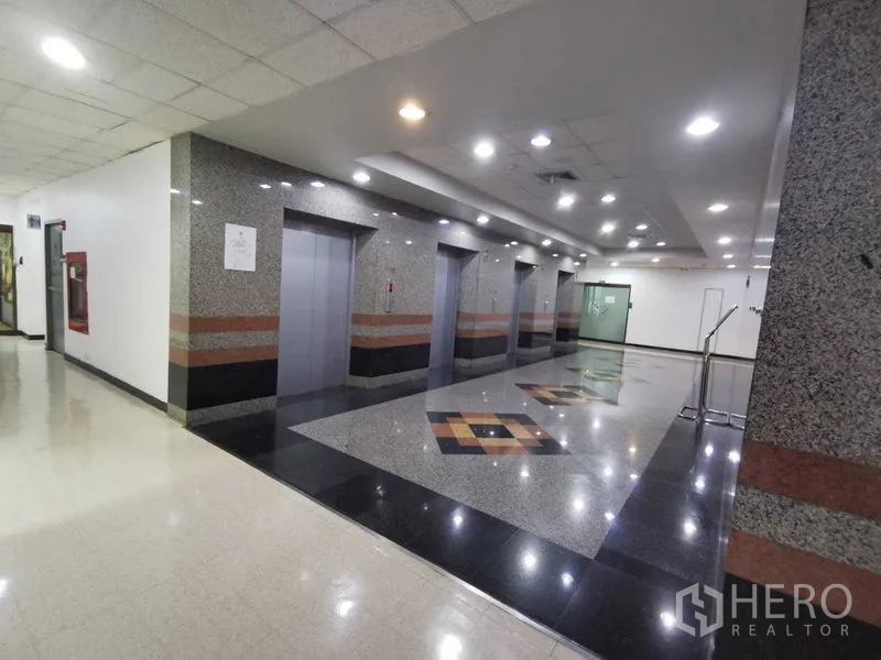 办公空间 出租在Watthana, Bangkok - 电梯大厅，花岗岩装饰，多部电梯与筒灯。