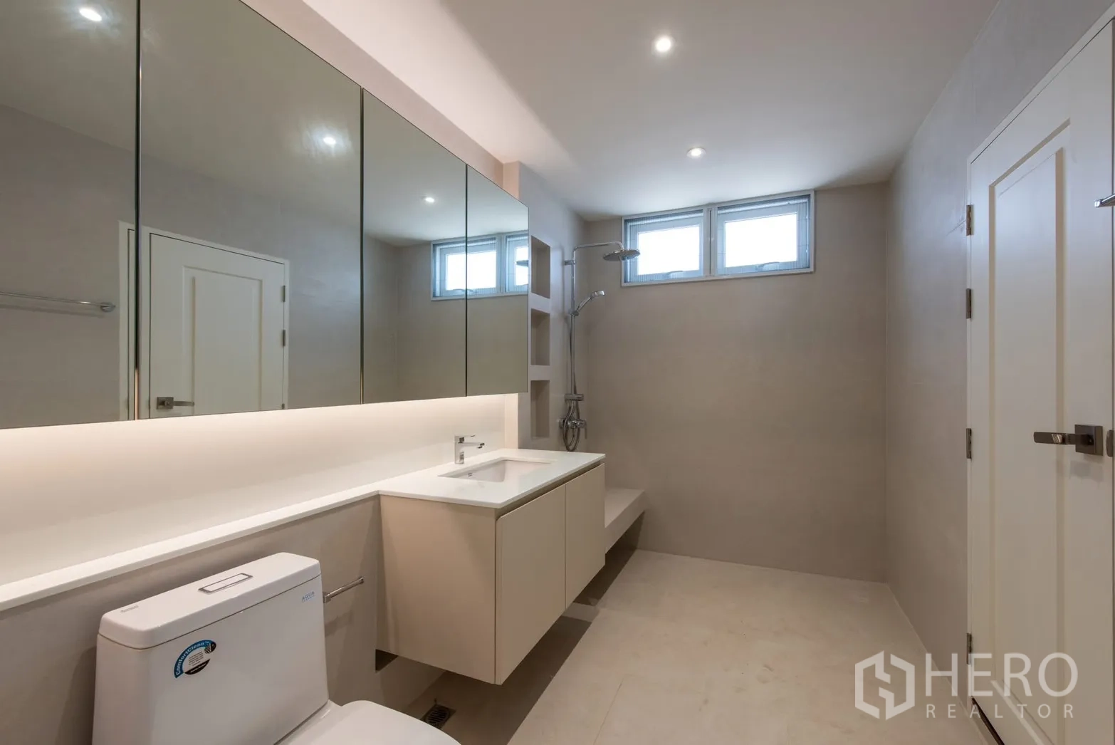 Detached House for sale in Bang Phli, Samut Prakan - Modern bathroom with large mirrored cabinets, vanity and walk-in shower area.