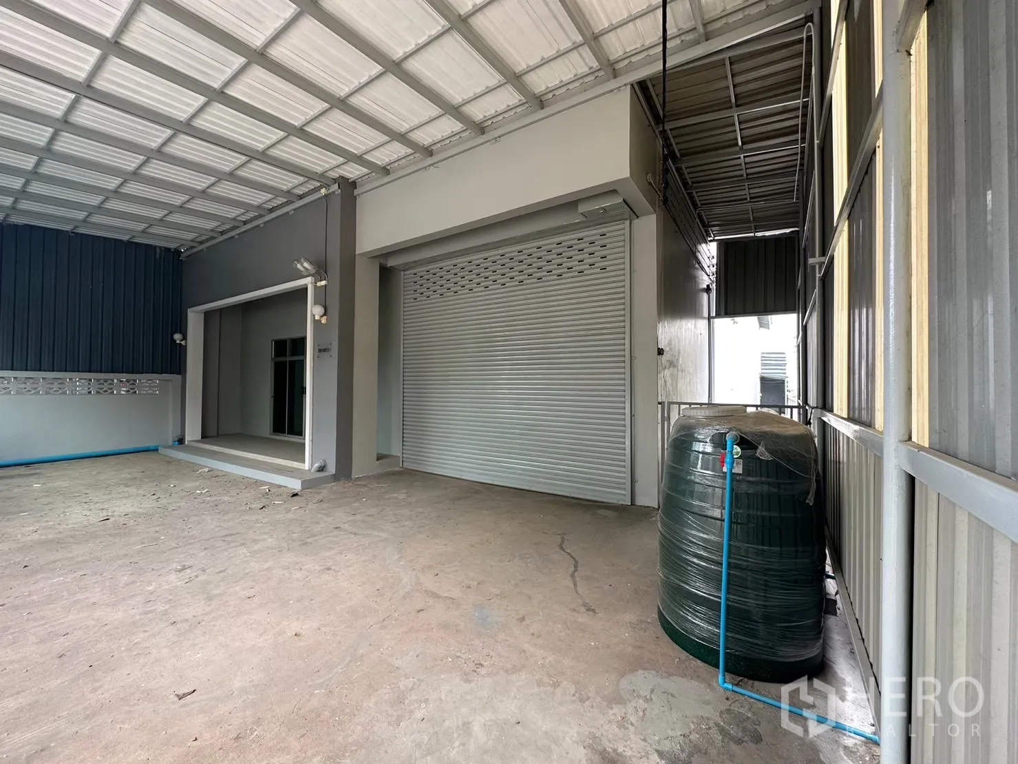 โรงงาน for rent in Bang Bua Thong, Nonthaburi - ประตูม้วนกว้างและลานโหลดสินค้าคลุมหลังคาพร้อมถังเก็บน้ำ