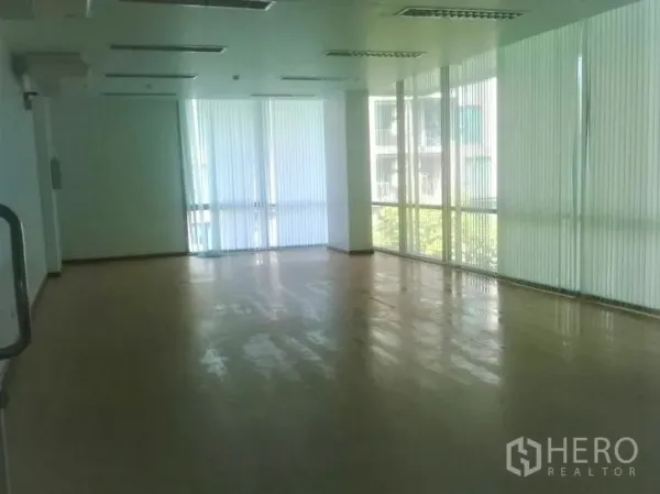 办公空间 出租在Phra Khanong, Bangkok - 采光充足的空置办公室，转角落地窗配百叶，天花板荧光灯。