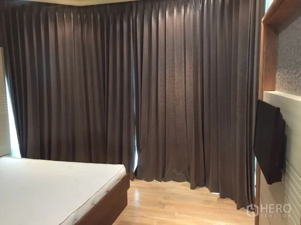 คอนโด ให้เช่าในWatthana, Bangkok - ห้องนอนพื้นไม้ ทีวีติดผนัง และผ้าม่านกันแสงทึบทั้งผืน