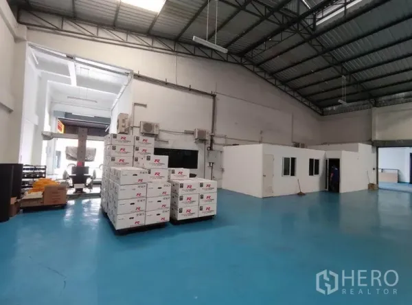 Warehouse for rent in Bang Phli, Samut Prakan - High-ceiling warehouse hall with blue epoxy floor and a partitioned office.