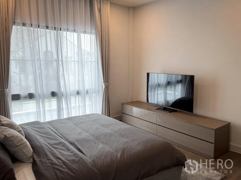 独立式住宅 出租或出售 - 客卧配低柜电视和落地窗。