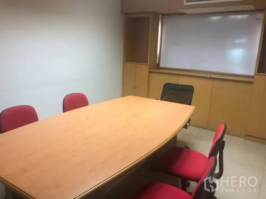 办公空间 出租在Sathon, Bangkok - 会议室配木质长桌、红色椅子、内置柜与白板。