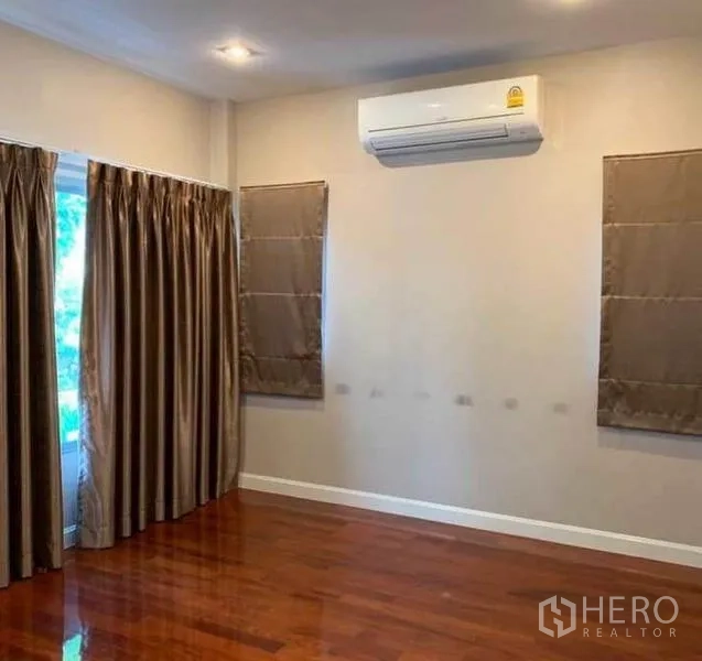 独立式住宅 出售在Mueang Pathum Thani, Pathum Thani - 宽敞卧室，木地板、遮光窗帘与壁挂空调。