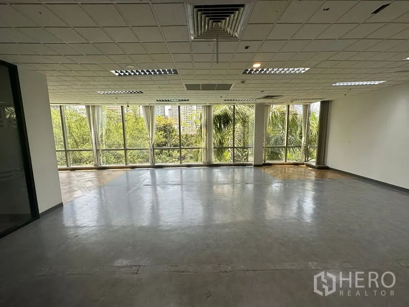 Office Space for rent - Corner workspace with wraparound floor-to-ceiling windows and park-like views.