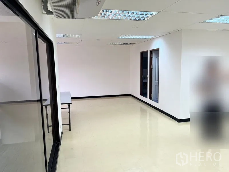 办公空间 出租在Pathum Wan, Bangkok - 带玻璃隔断的办公室一角，吊顶空调与可布置工位的开放空间