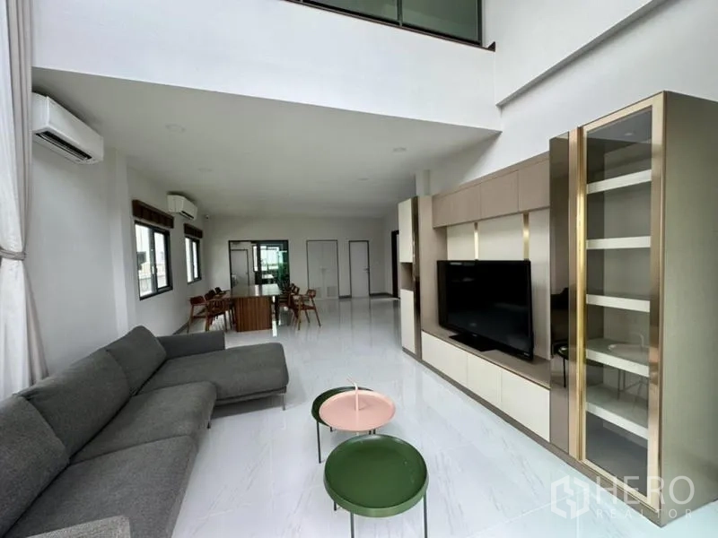 独立式住宅 出租在Bang Phli, Samut Prakan - 挑高客厅，转角沙发与一体化电视柜。