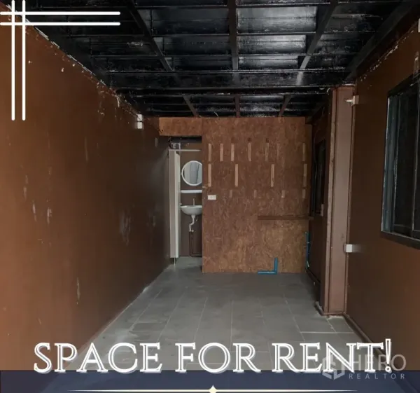 零售空间 出租在Watthana, Bangkok - 空置20㎡商铺，深色天花、瓷砖地面，后方带洗手间与洗手盆。