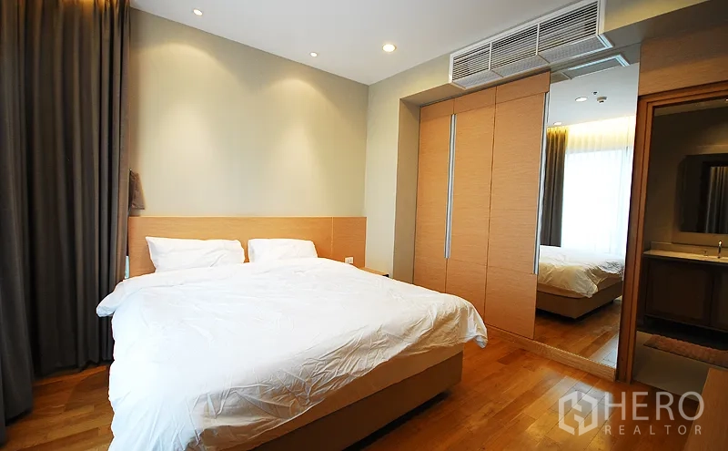 คอนโด ให้เช่าในKhlong Toei, Bangkok - ห้องนอนกว้าง เตียงคิงไซส์ ตู้เสื้อผ้าบิวท์อินบานกระจก พื้นไม้ และทางเข้าห้องน้ำ