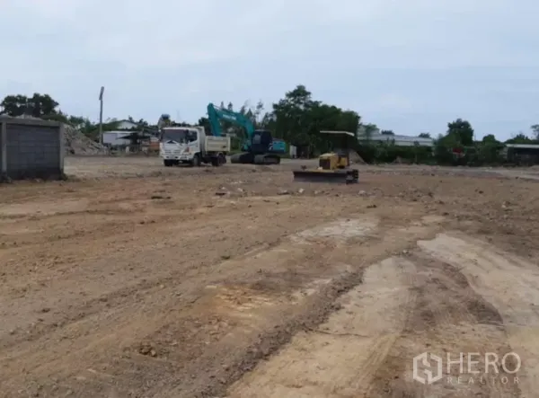 Land for sale in Khlong Toei, Bangkok - Dump truck and excavator working on a large cleared land site.