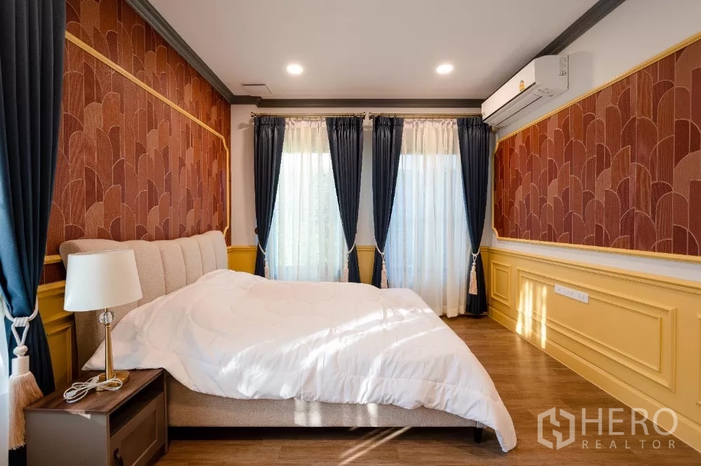 Detached House for rent or sale in Khlong Toei, Bangkok - Guest bedroom with warm patterned wallpaper, navy curtains and yellow wainscoting.