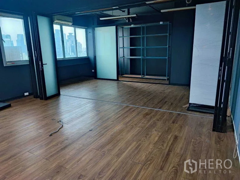 办公空间 出租在Watthana, Bangkok - 宽敞办公区，木地板、可折叠玻璃隔断与置物架凹位。