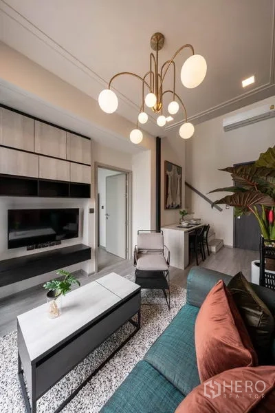 คอนโด ให้เช่าหรือขายในPhra Khanong, Bangkok - โซนนั่งเล่นเปิดโล่ง ทีวีติดผนังพร้อมตู้เก็บของ โคมไฟดีไซน์ โซฟา และทางเข้าครัวขนาดกะทัดรัด