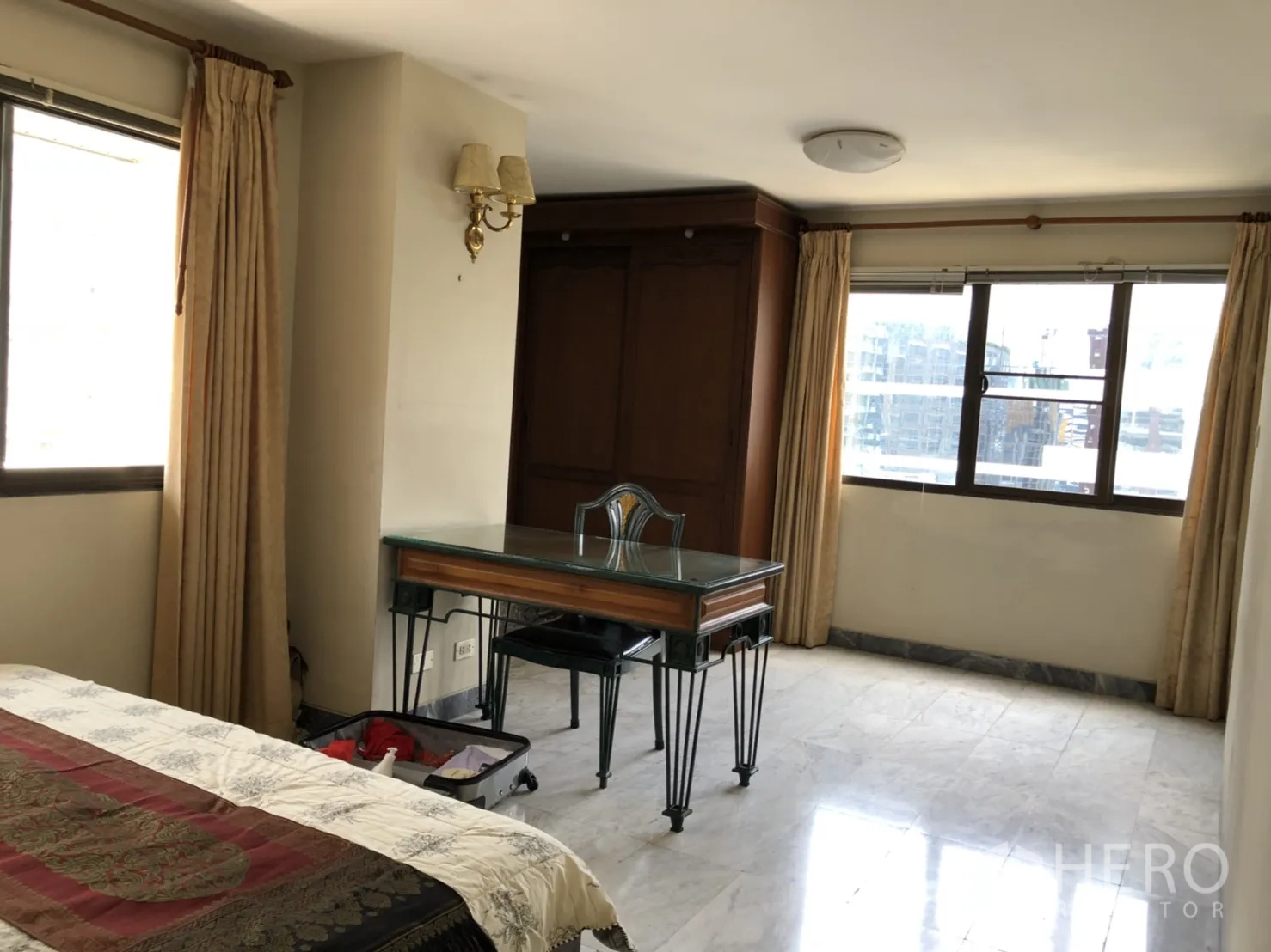 คอนโด ให้เช่าในPathum Wan, Bangkok - มุมห้องนอนสว่างพร้อมโต๊ะทำงานกระจก พื้นหินอ่อน และหน้าต่างบานกว้าง