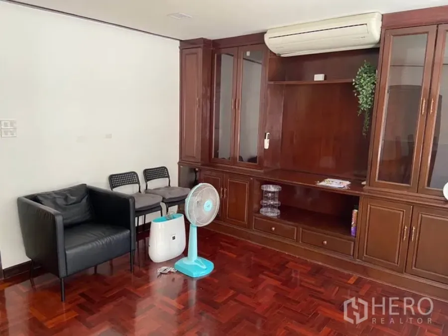 ทาวน์เฮาส์ ให้เช่าในKhlong Toei, Bangkok - พื้นที่นั่งเล่นพื้นปาร์เกต์ พร้อมตู้บิวท์อินไม้ เครื่องปรับอากาศ และเก้าอี้นั่งสบาย