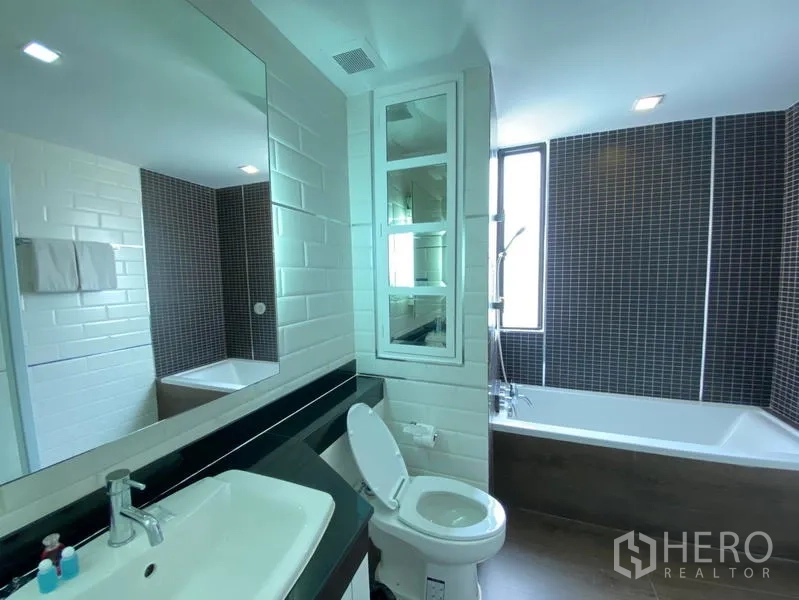 คอนโด ให้เช่าในKhlong Toei, Bangkok - ห้องน้ำมีเคาน์เตอร์ซิงก์ยาว อ่างอาบน้ำพร้อมฝักบัว และผนังกระเบื้องสวยงาม