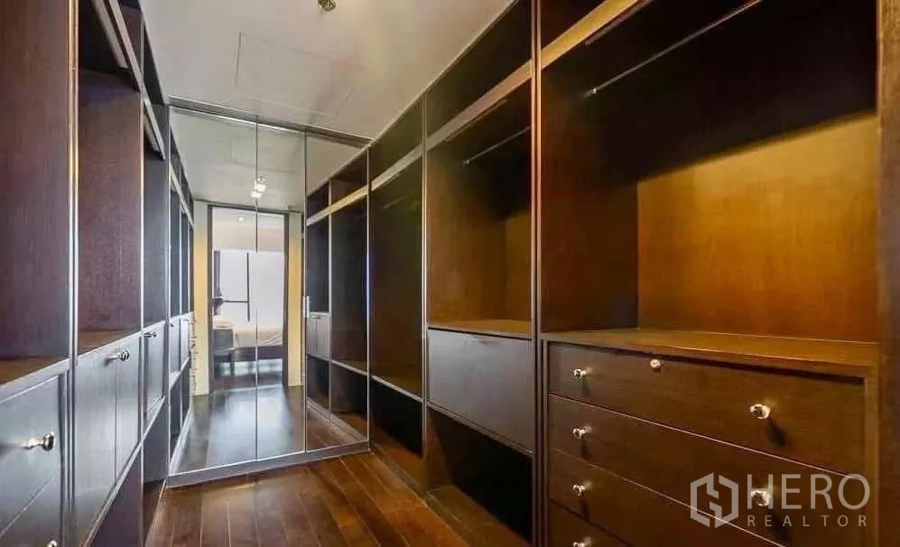 Condominium for rent in Sathon, Bangkok - Walk-in closet with mirrored doors and dark wood cabinetry.