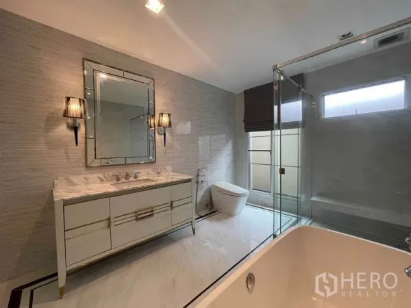 Detached House for rent in Bang Khen, Bangkok - Modern bathroom with marble vanity, mirrored lighting, glass shower and soaking tub.