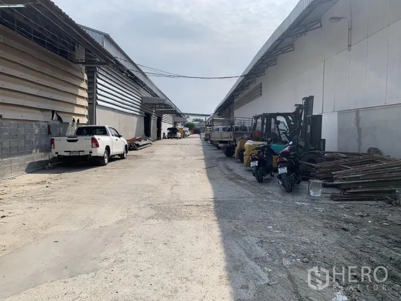 คลังสินค้า ให้เช่าในBueng Kum, Bangkok - ทางสัญจรภายในโครงการโกดัง บึงกุ่ม กรุงเทพฯ มีรถบรรทุก โฟล์คลิฟต์ และวัสดุสำหรับขนถ่ายสองฝั่ง