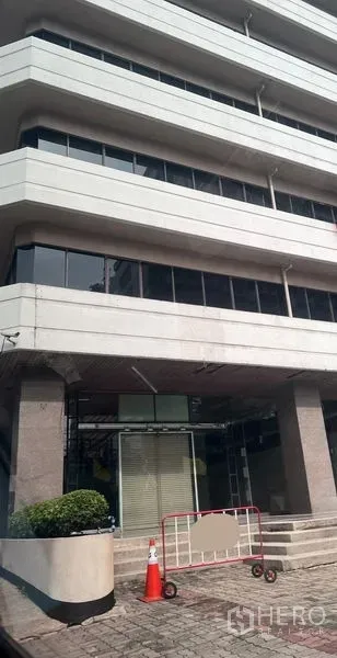 零售空间 出租 - 现代商业楼外立面，底层零售入口配台阶与绿化花槽。