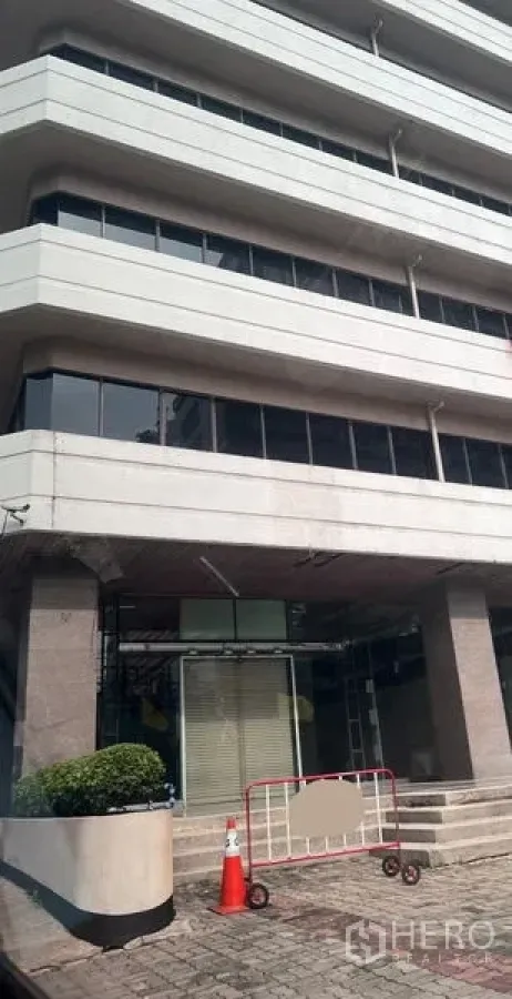 零售空间 出租 - 现代商业楼外立面，底层零售入口配台阶与绿化花槽。