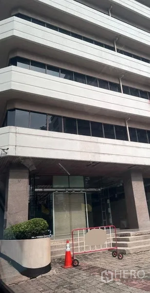 零售空间 出租 - 现代商业楼外立面，底层零售入口配台阶与绿化花槽。