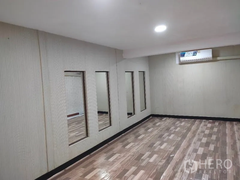 店屋 出租或出售在Bang Rak, Bangkok - 紧凑工作室空间，镜面墙板、木纹地板与吸顶灯。