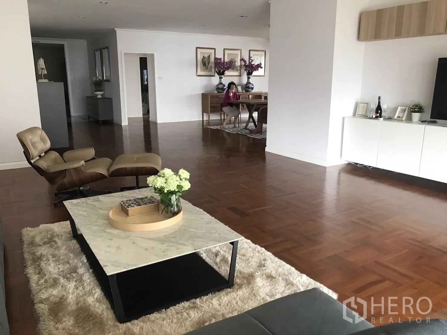 คอนโด ให้เช่าในBangkok - พื้นที่นั่งเล่นกว้างพร้อมเก้าอี้เลานจ์ โต๊ะกลางหินอ่อน และพื้นไม้