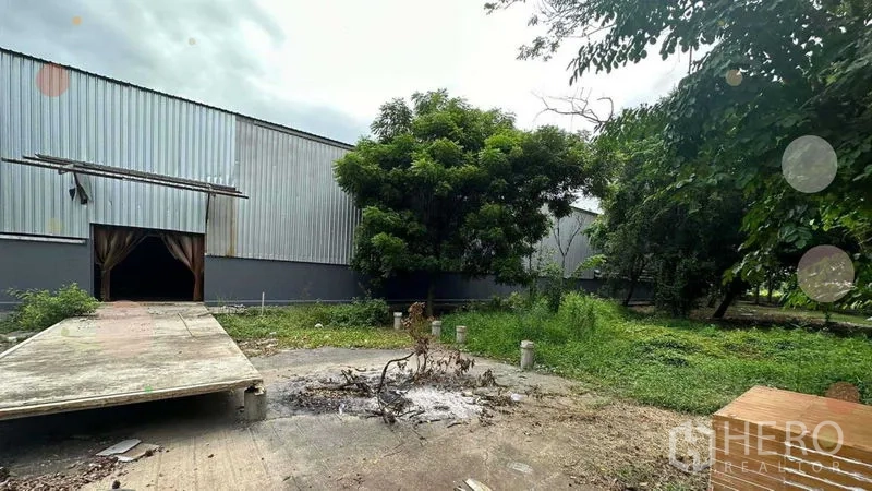 Warehouse for rent in Phra Nakhon Si Ayutthaya - Metal-clad warehouse exterior with loading ramp and mature trees in Bang Sai.