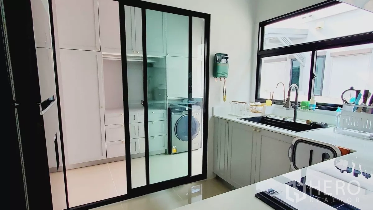 บ้าน ให้เช่าในLat Krabang, Bangkok - ครัวเชื่อมห้องซักรีดด้วยประตูกระจกกรอบดำ และซิงก์ขนาดใหญ่