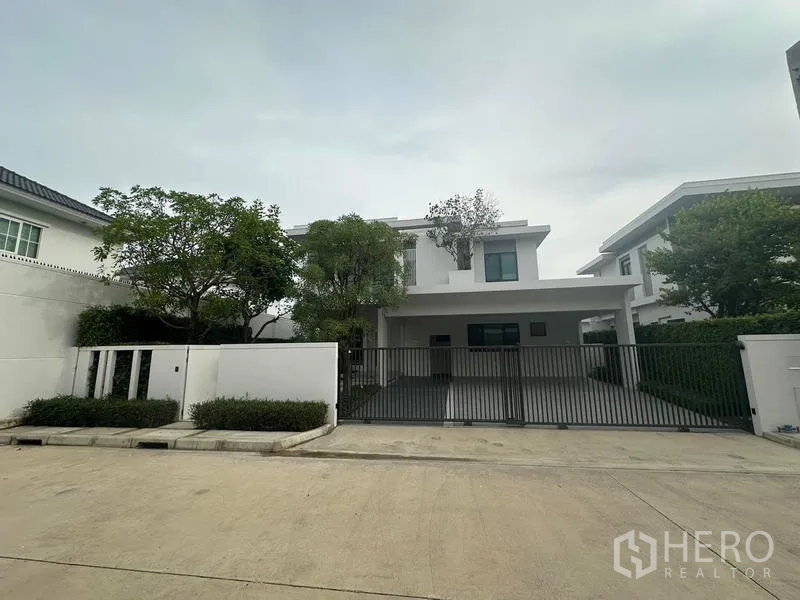 Detached House for rent in Samut Prakan - Front elevation of the detached house with wide carport and gate.