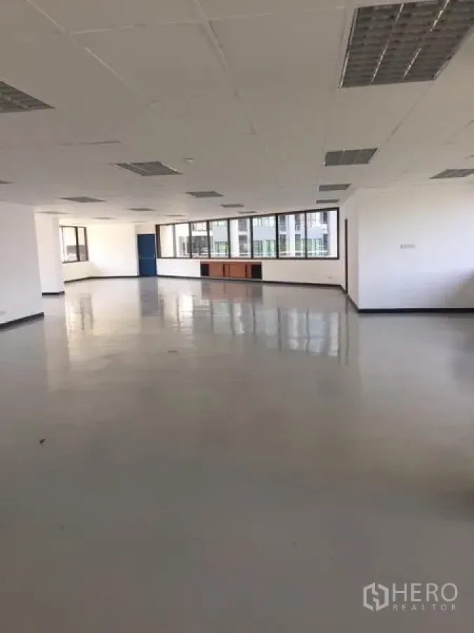 Office Space for rent in Bang Kapi, Bangkok - Open-plan office floor in Bang Kapi with large windows, white walls, grid ceiling lights and glossy floors.