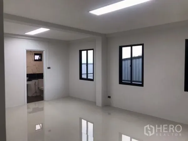 Warehouse for rent or sale in Nong Chok, Bangkok - Bright office room in the warehouse with glossy tile floor, two black-frame windows and a door to the restroom.