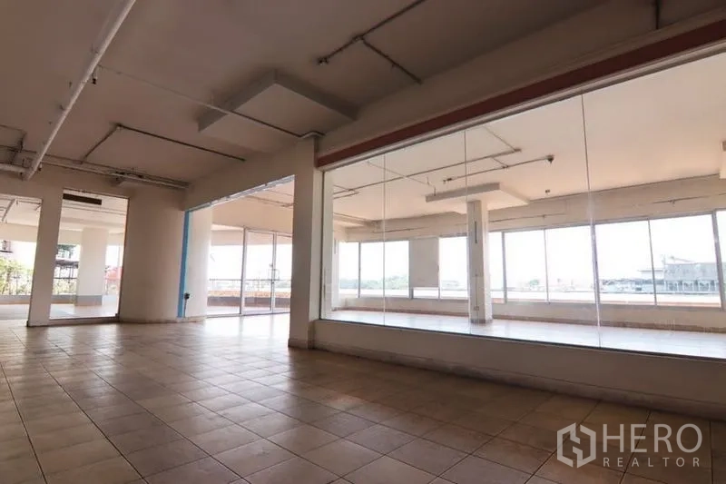 零售空间 出租在Yan Nawa, Bangkok - 室内面向整面玻璃展示墙，并有滑动玻璃门通向露台。