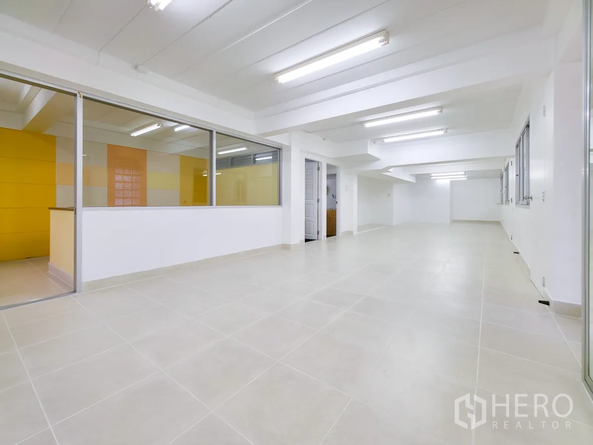 办公室 for rent in Khlong Toei, Bangkok - 宽敞办公区，带黄墙玻璃隔断与吊顶灯。