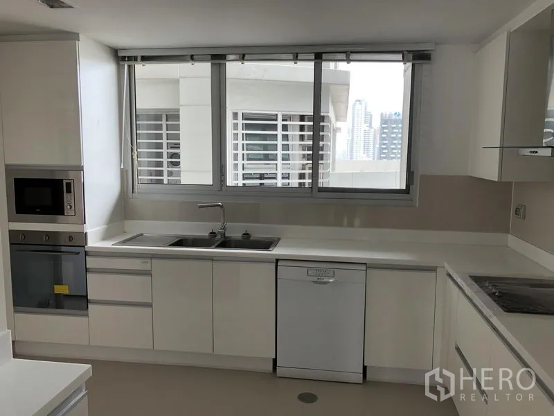 อพาร์ทเมนท์ ให้เช่าในWatthana, Bangkok - ห้องครัวสไตล์โมเดิร์นสีขาว พร้อมเตาอบ ไมโครเวฟ อ่างล้างจานคู่ เครื่องล้างจาน และหน้าต่างวิวเมือง