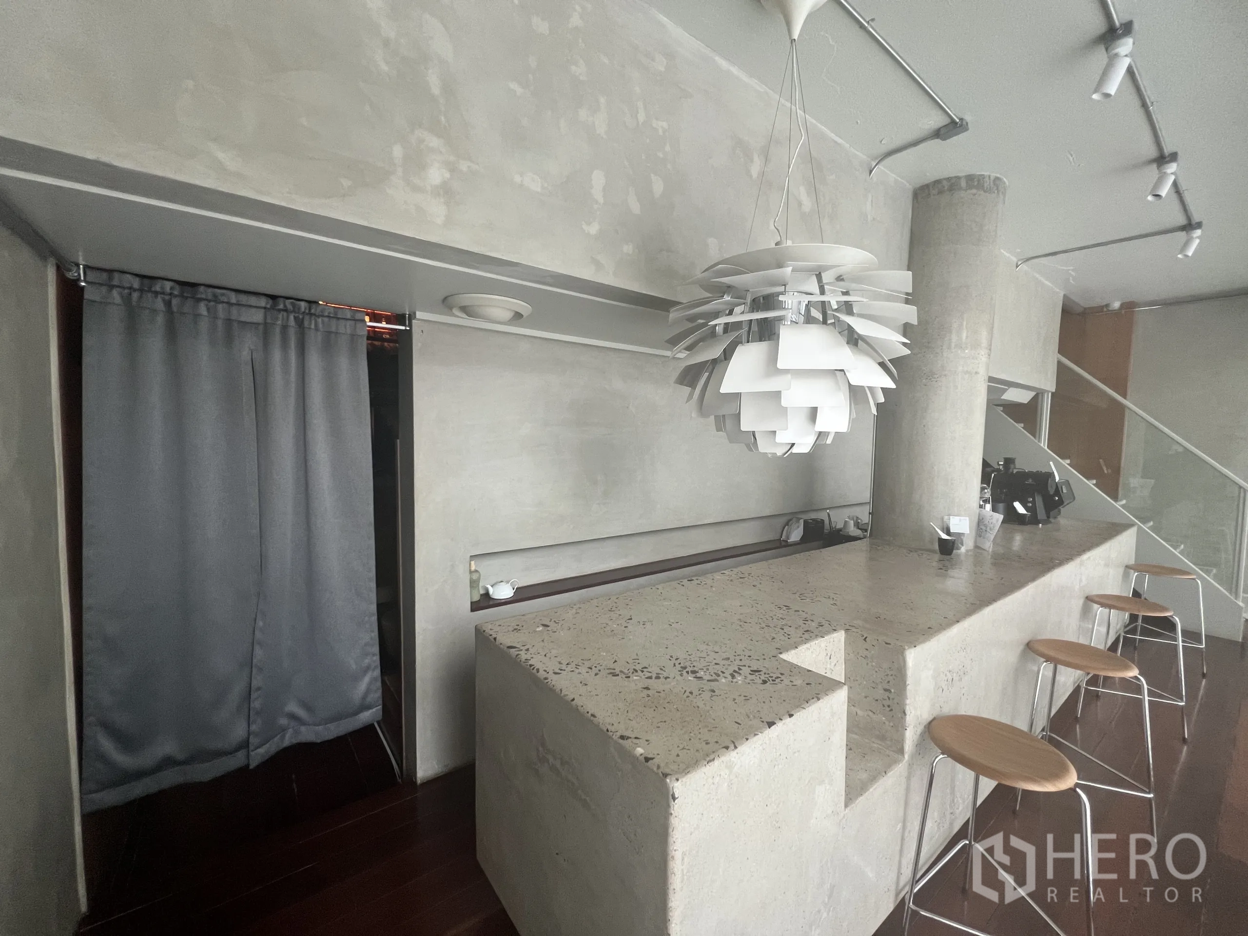 零售空间 出租在Watthana, Bangkok - 极简混凝土吧台，艺术吊灯与吧凳。