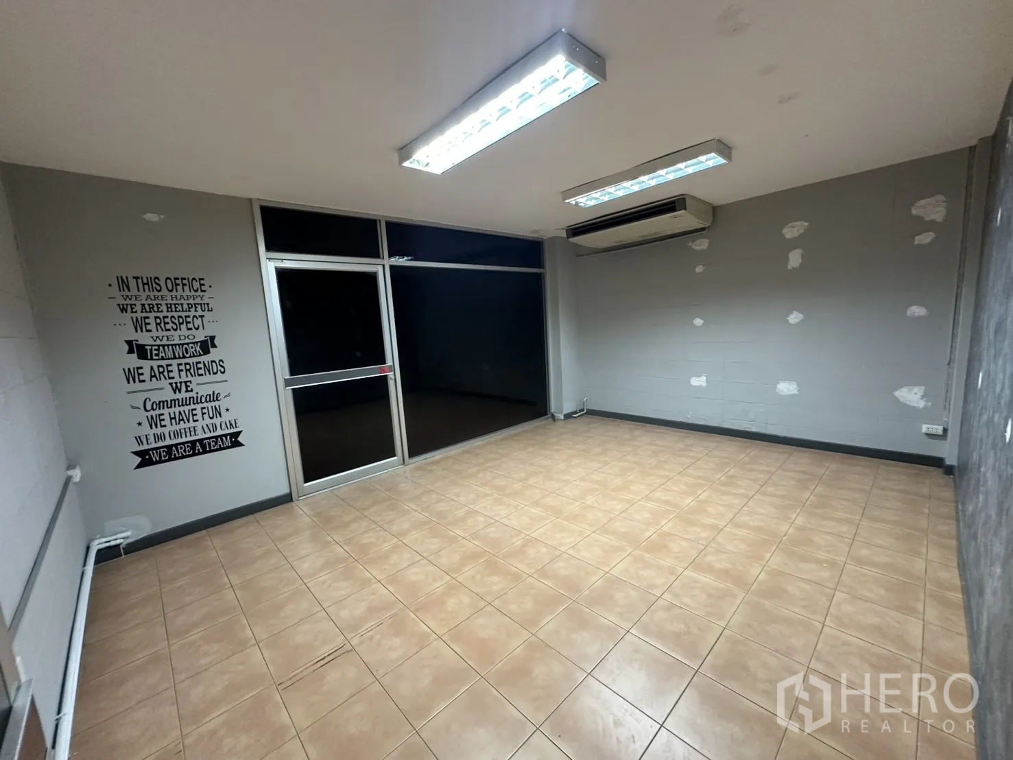 Warehouse for rent in Bang Na, Bangkok - Tiled office with air conditioner and glass frontage.