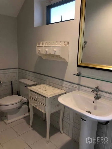 独立式住宅 出租在Bang Na, Bangkok - 浴室配立柱式洗手盆、马桶、框镜与复古边几。