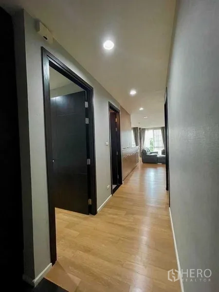 公寓 出租在Watthana, Bangkok - 走廊光线充足，木地板通往客厅与卧室。